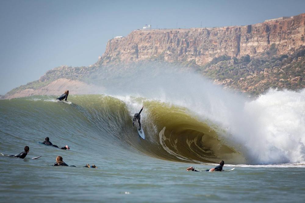 Surfista dentro il tubo di un'onda sotto la scogliera di Safi