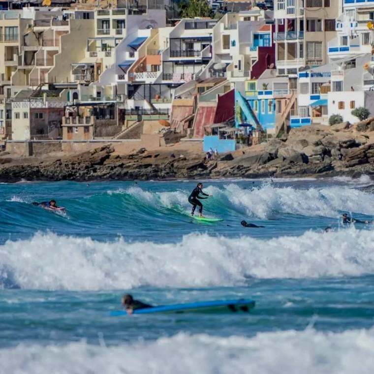 Surfista in acqua davanti al villaggio di Taghazout