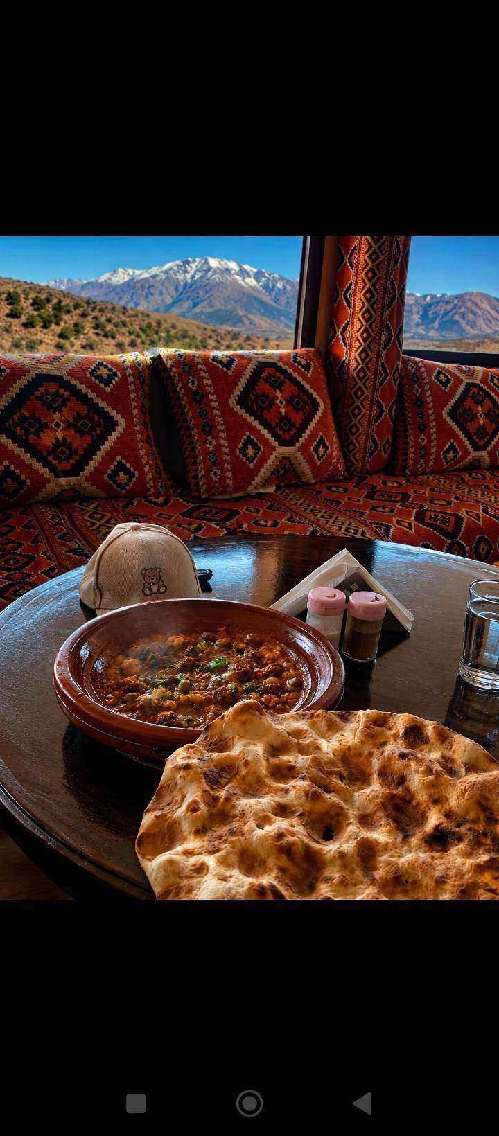 Tajine berbero servito con vista sull'Alto Atlante innevato